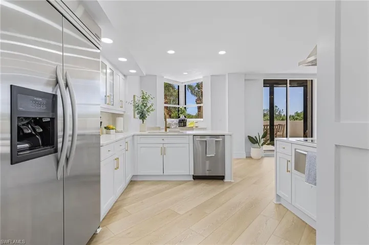 Kitchen with plenty of natural light, appliances with stainless steel finishes, light hardwood / wood-style flooring, and white cabinetry