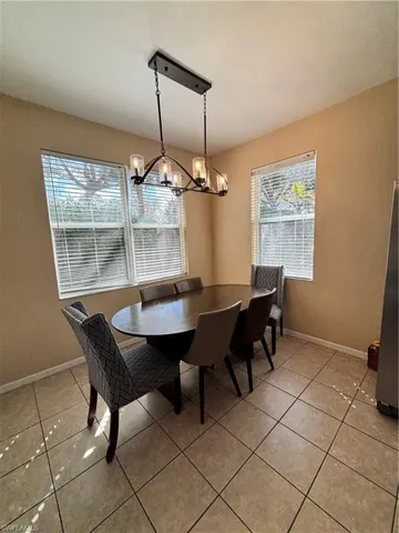 Dining space with hanging lights and light tile patterned flooring