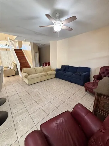 Living room featuring light tile patterned floors and a ceiling fan