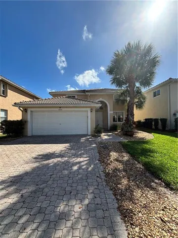 Mediterranean / spanish-style house with stucco siding, a garage, decorative driveway, and a tiled roof