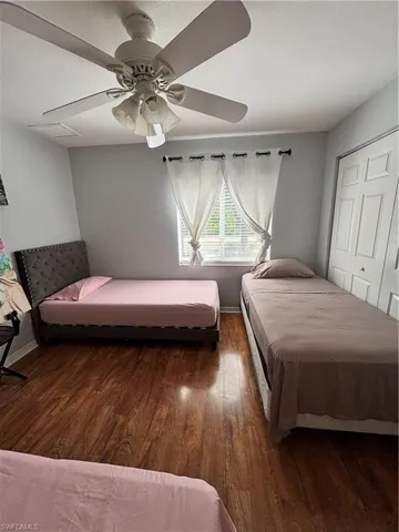 Bedroom with dark wood finished floors, a closet, and ceiling fan