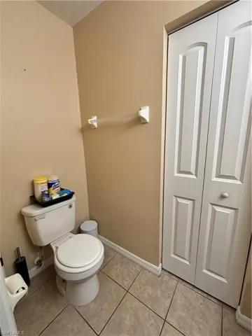 Bathroom with a closet and light tile patterned floors