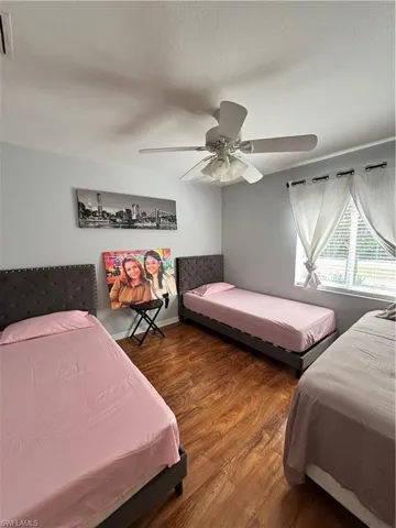 Bedroom with wood finished floors, ceiling fan, and a textured ceiling