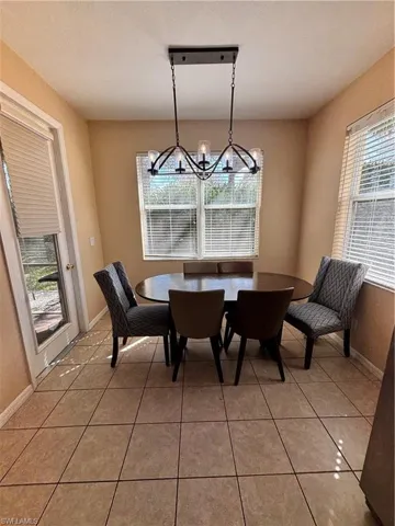 Dining space with light tile patterned flooring and hanging lights