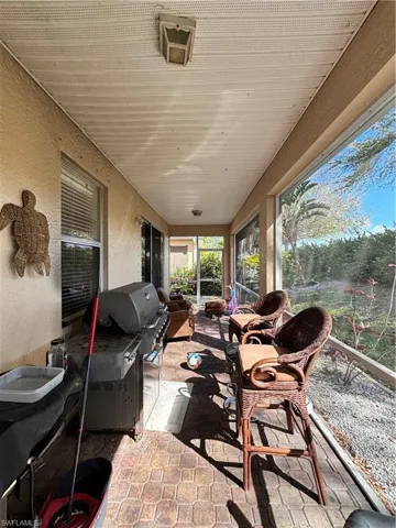 Sunroom featuring a textured wall and stone finish flooring