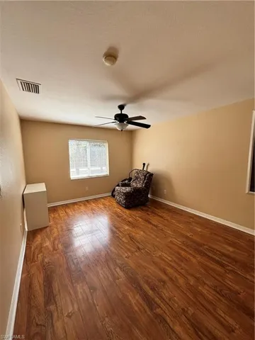 Unfurnished room with dark wood-style floors, ceiling fan, and a textured ceiling