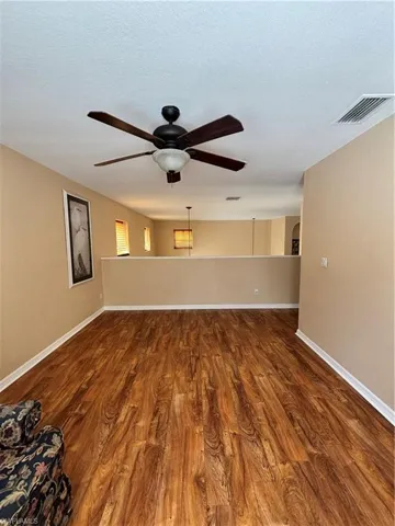 Unfurnished room with dark wood-style floors, a ceiling fan, and a textured ceiling