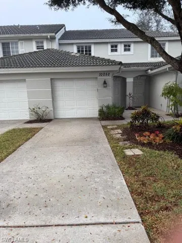 Traditional home with concrete driveway, stucco siding, and a tile roof