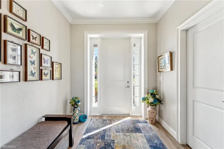 Entrance foyer featuring ornamental molding, baseboards, and wood finished floors