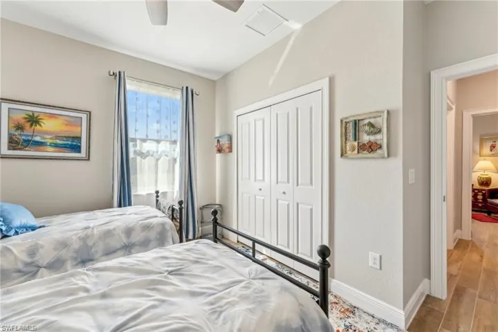 Bedroom featuring light wood-type flooring, baseboards, visible vents, a ceiling fan, and a closet