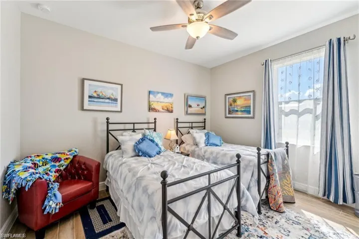 Bedroom with a ceiling fan, baseboards, and wood finished floors