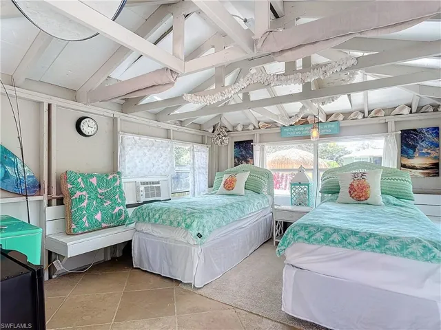 Bungalow, featuring cooling unit, vaulted ceiling with beams, and light tile patterned flooring