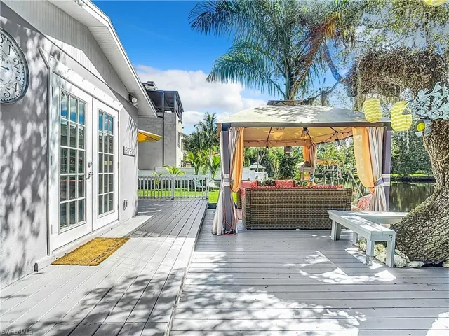 Wooden deck featuring french doors, a gazebo, and a water view