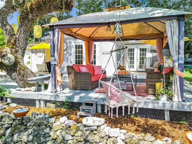 Rear view of house featuring french doors, an outdoor living space, and a gazebo