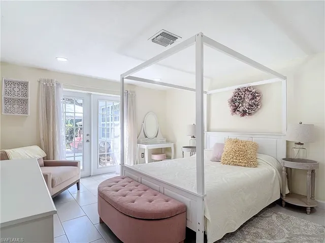 Master bedroom with riverside view, tile flooring, and french doors leading out to the open outdoor patio