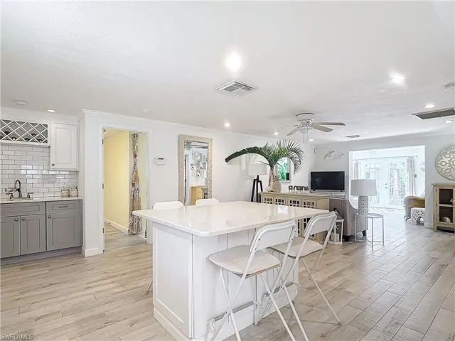 Kitchen featuring ceiling fan, light hardwood / wood-style floors, sink, and a center island