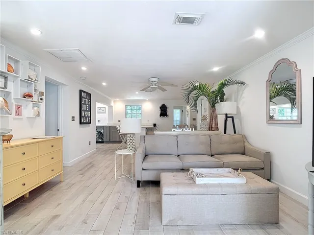 Living room with light hardwood / wood-style flooring, ceiling fan, and crown molding
