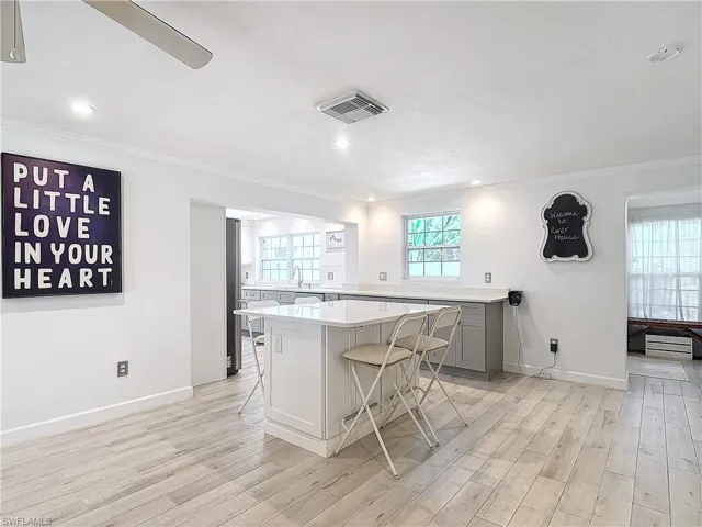 Kitchen featuring a kitchen breakfast bar, light hardwood / wood-style floors, gray cabinets, and a kitchen island