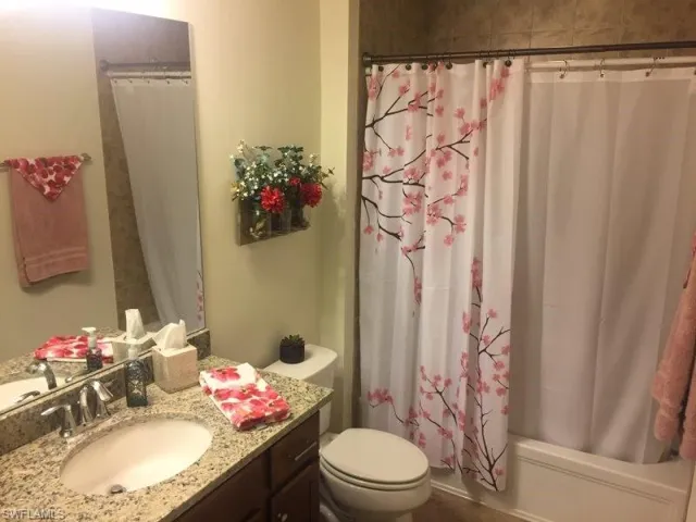 Full bath featuring shower / bath combination with curtain and vanity
