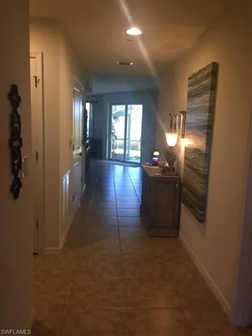 Corridor featuring dark tile patterned flooring and baseboards