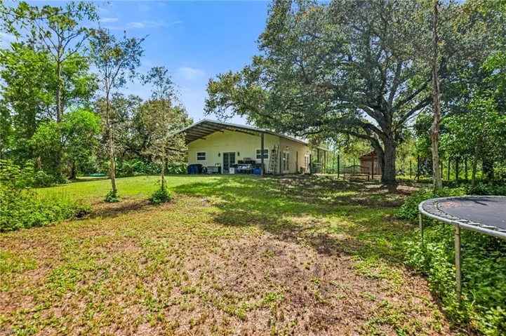 View of grassy yard with a trampoline