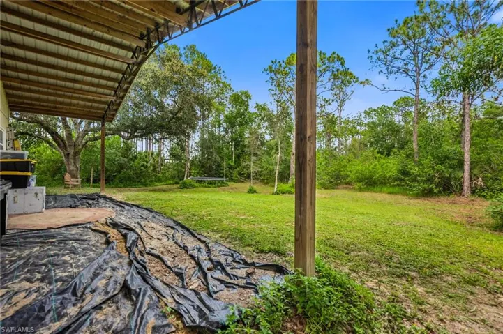 View of grassy yard featuring a patio area