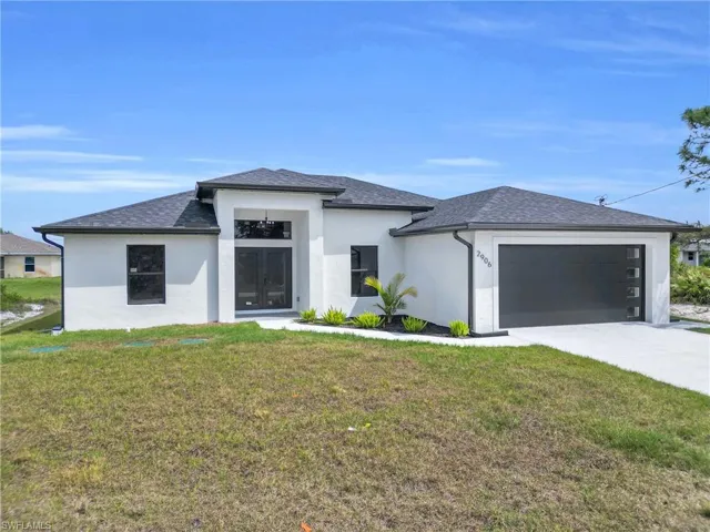 Prairie-style home with an attached garage, roof with shingles, concrete driveway, and a front yard
