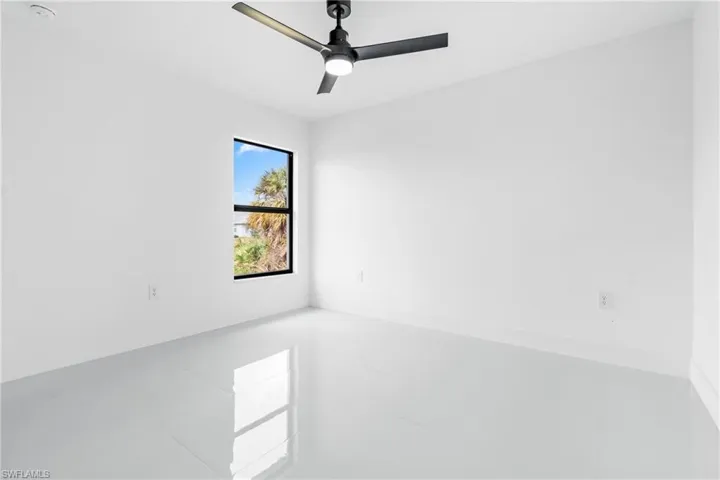 Empty room featuring tile patterned floors and ceiling fan