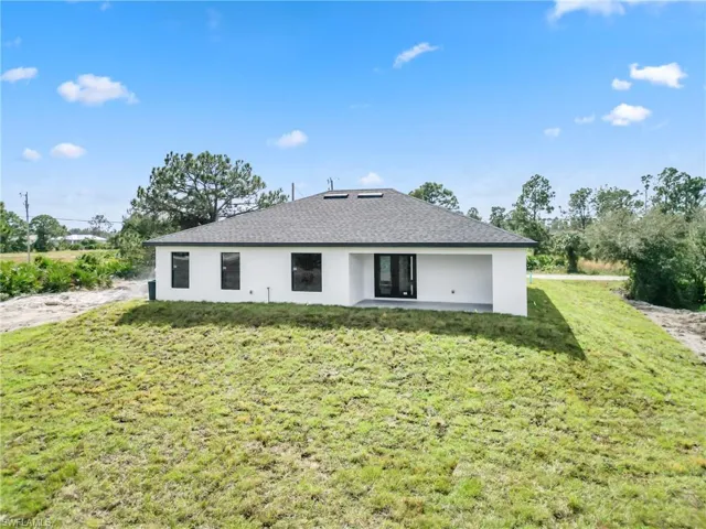 Back of house with a patio area and a lawn