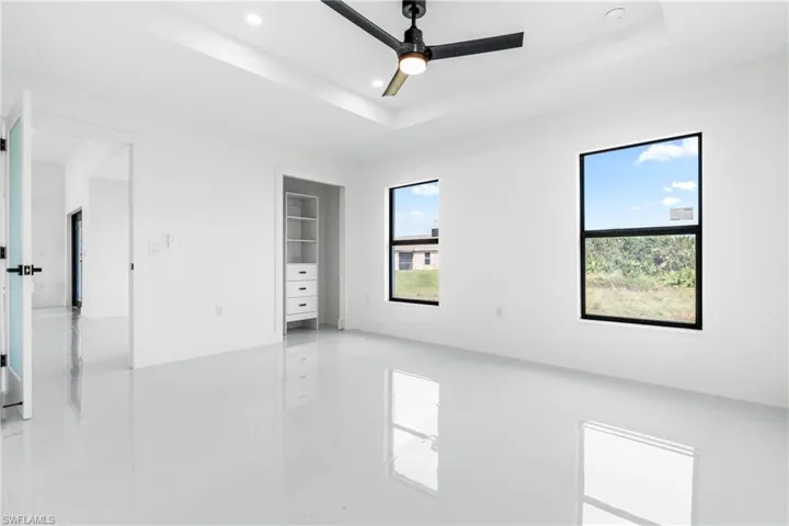 Spare room featuring a tray ceiling and ceiling fan