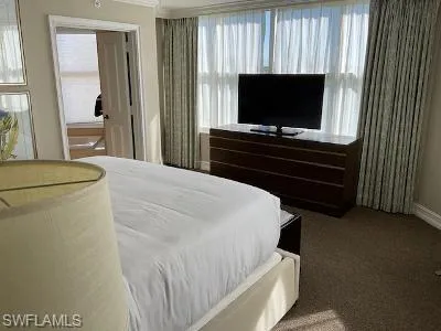 Bedroom with carpet floors, multiple windows, and ceiling fan
