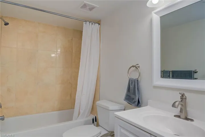 Full bath with shower / tub combo with curtain and vanity