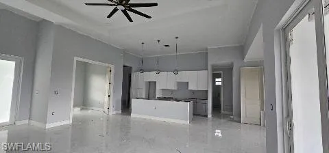 Kitchen featuring a high ceiling, ceiling fan, and gray cabinets