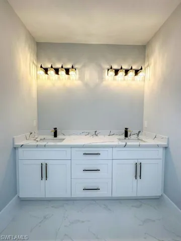 Bathroom featuring tile floors and double vanity