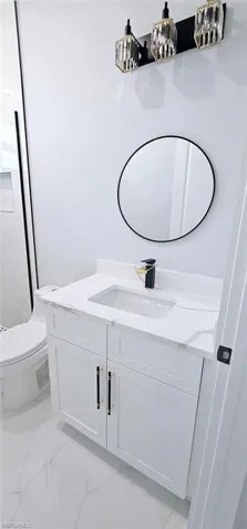 Bathroom featuring tile flooring, vanity, and toilet