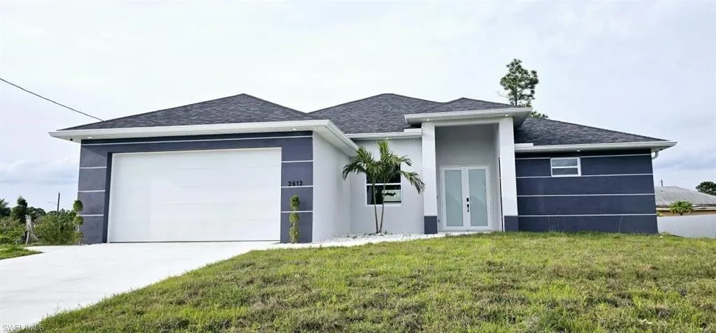 View of front of house featuring a front yard and a garage