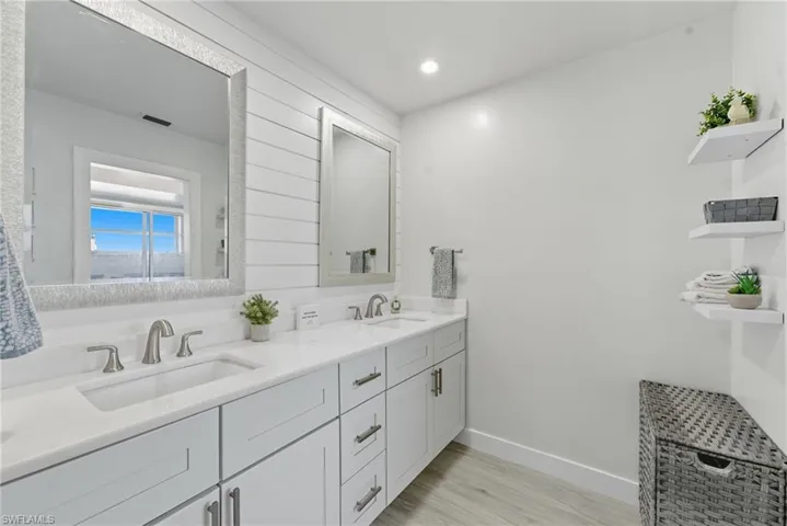 Bathroom with double vanity, light wood-style flooring, and recessed lighting
