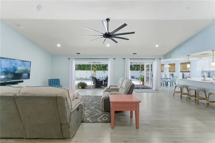 Living area featuring vaulted ceiling, recessed lighting, ceiling fan, and light wood-type flooring