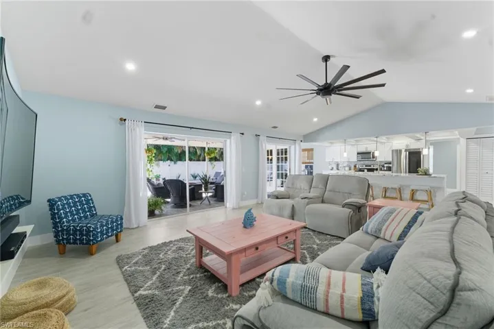 Living room featuring lofted ceiling, recessed lighting, light wood-style flooring, and a ceiling fan