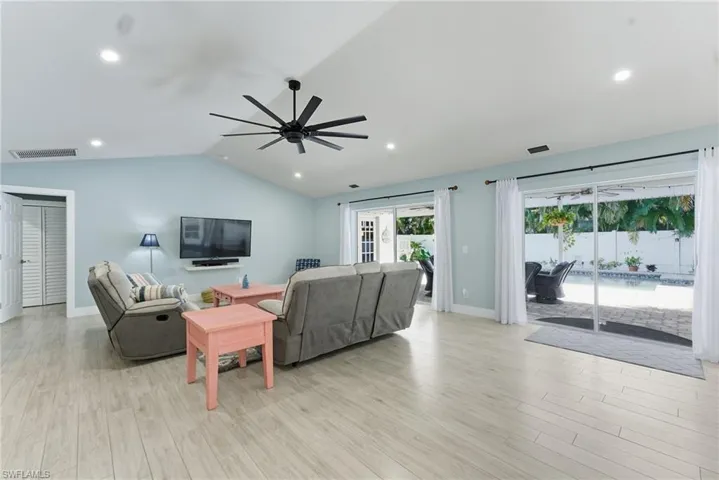 Living room featuring lofted ceiling, light wood-style flooring, recessed lighting, and a ceiling fan