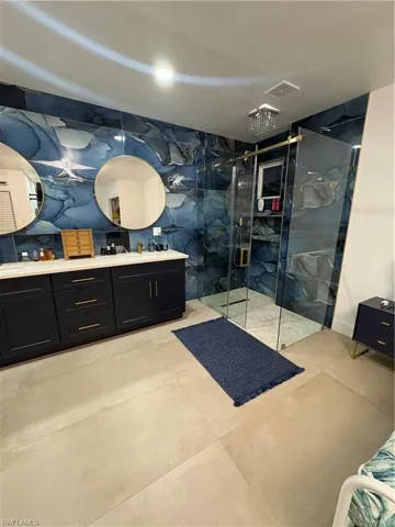Bathroom featuring vanity and a shower with shower door