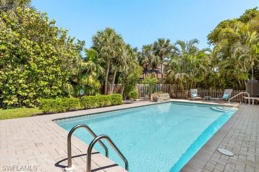 View of swimming pool featuring a patio area, a fenced in pool, and fence