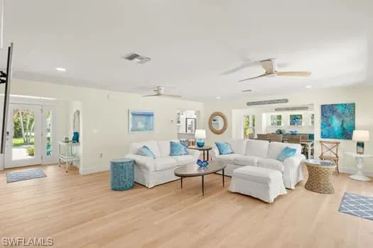 Living area featuring baseboards, light wood-style flooring, and a ceiling fan