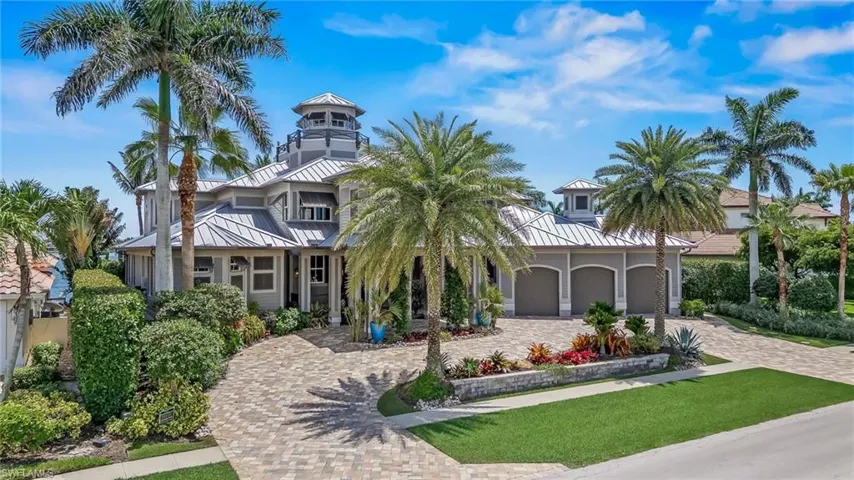 View of front of home with a standing seam metal roof, decorative driveway, an attached garage, and a front yard