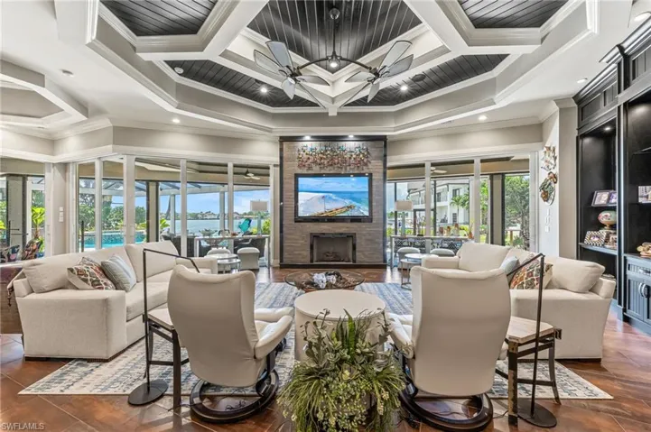 Living area featuring ornamental molding, coffered ceiling, a large gas fireplace, and beamed ceiling