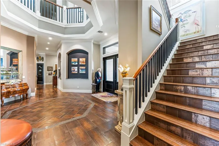 Entryway with a towering ceiling, staircase to second floor, recessed lighting, and ornamental molding