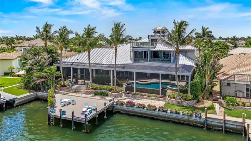 Rear view of property featuring a water view, a patio area, a pool with connected hot tub, and screen enclosure