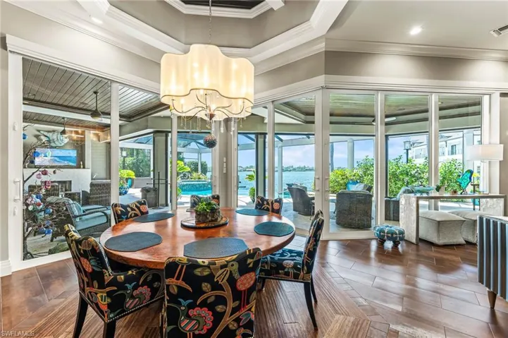 Dining area featuring ornamental molding, a water view, and a chandelier
