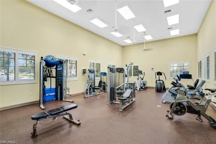 Exercise room with a high ceiling and a ceiling fan