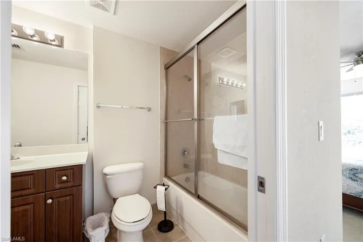Bathroom featuring enclosed tub / shower combo, a ceiling fan, vanity, connected bathroom, and tile patterned floors